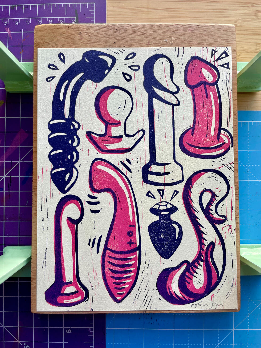 Toy Collection | buy prints Linocut print of a variety of sex toys in pink and dark purple: glass and silicone dildos, a g spot vibrator, and butt plugs.
