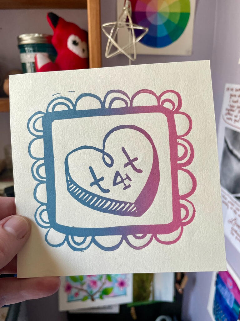 Linocut print of a conversation heart with the inscription "T4T". Printed in a baby blue and pink gradient.
